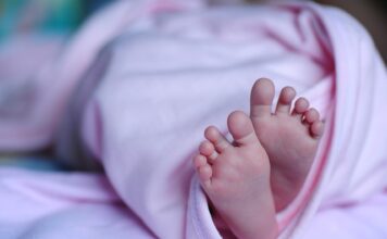 Jak ubrać noworodka w body przez głowę?